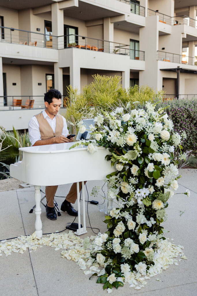 White piano for ceremony music, decorted with a cascare of flowers