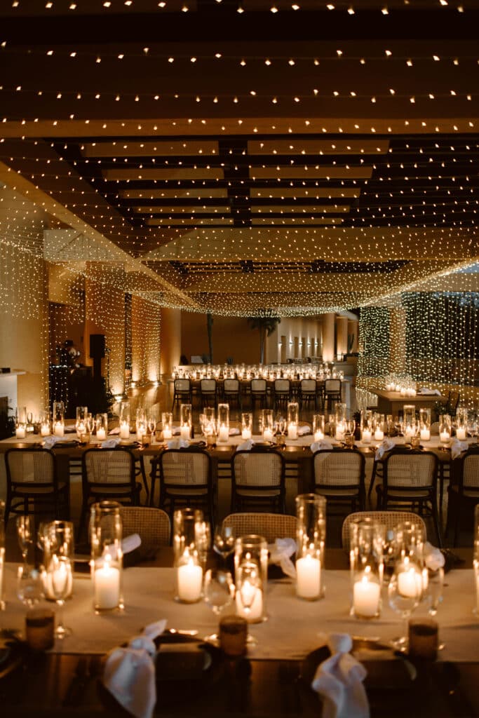 Luxury candlelit wedding reception at Fiesta Americana Los Cabos with fairy lights and long wooden tables