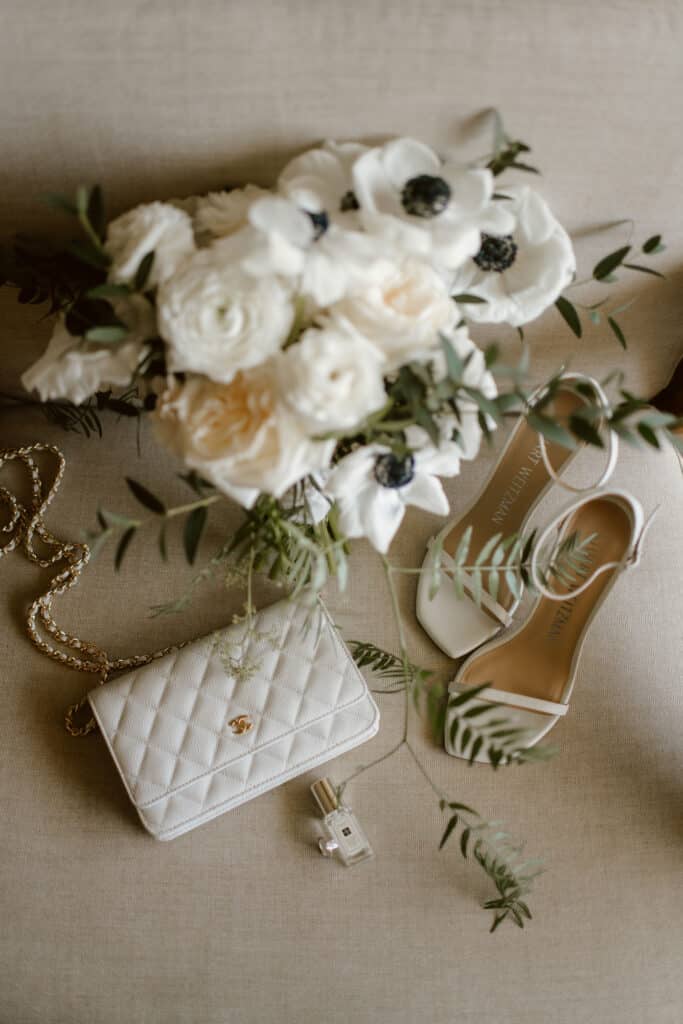 White bridal bouquet with anemones and roses, ivory heels and elegant accessories for a luxury Los Cabos wedding.